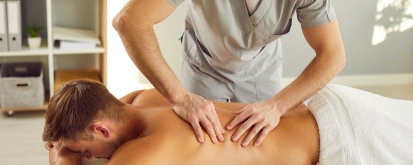 Chiropractor and massage therapist treating patient for back pain relief in Renton WA