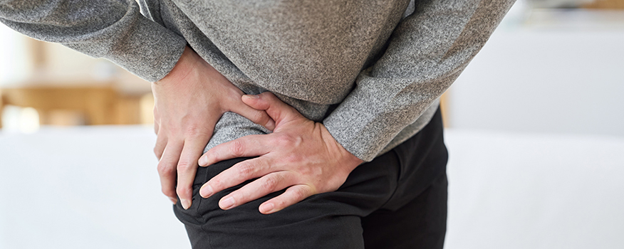 Woman experiencing hip pain while walking and discussing treatment options with a chiropractor in Renton WA.